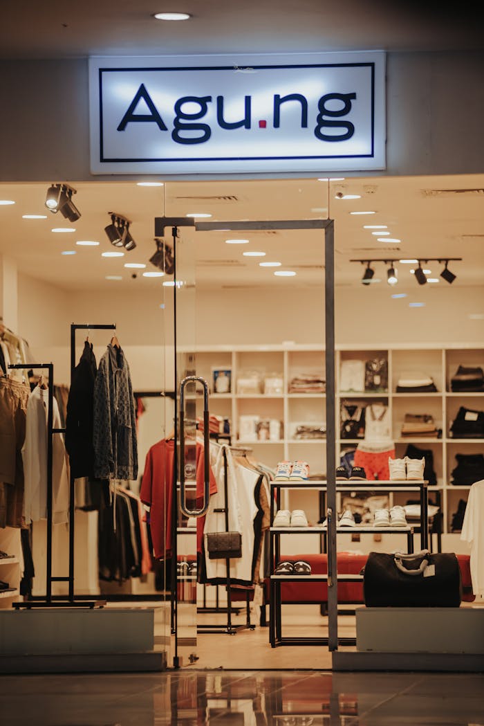 Stylish clothing store with modern design, displaying apparel and accessories under warm lighting.